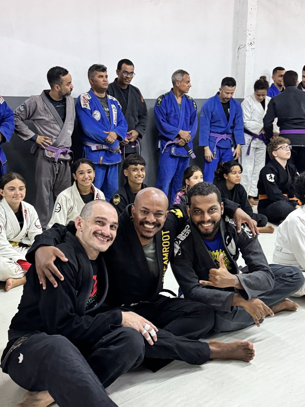 Professor Lou smiling on the mat with Team Passos coaches and students in Brazil