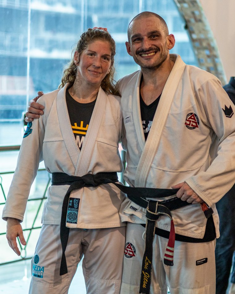 Professor Lou Armezzani and his wife, both in white gis and black belts, smiling after training in Brazil