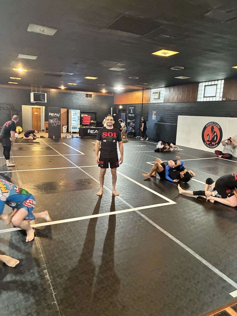 Coach standing on the mat during no-gi training