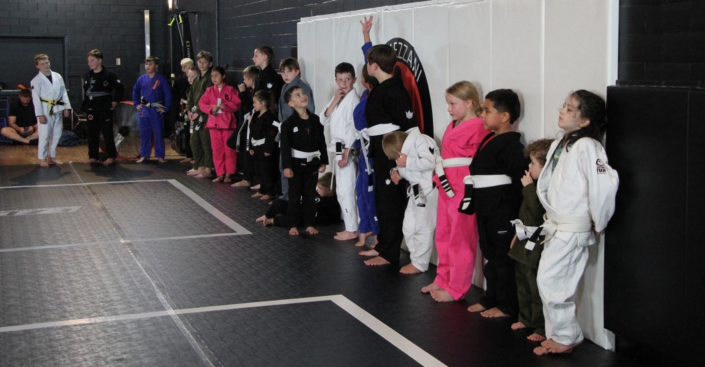 Kids in gis lined up along the wall ready for class